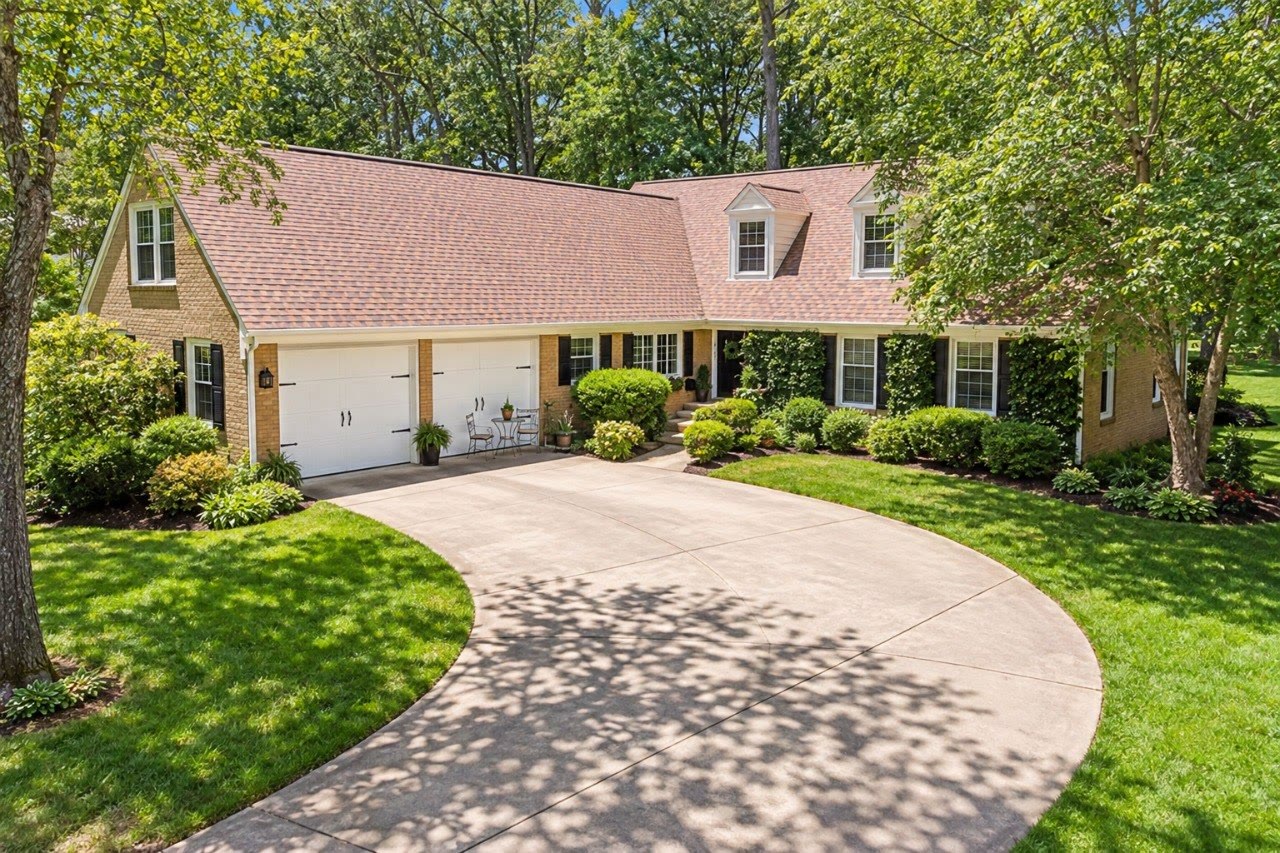 Landscaped single-story brick home in a wooded Crofton setting